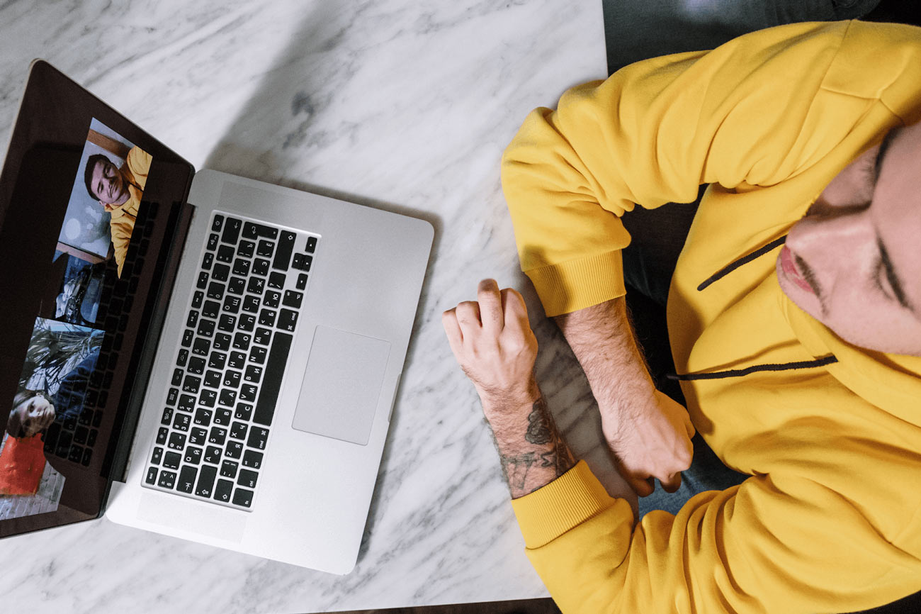 Kobieta analizuje profile LinkedIn na laptopie w kawiarni