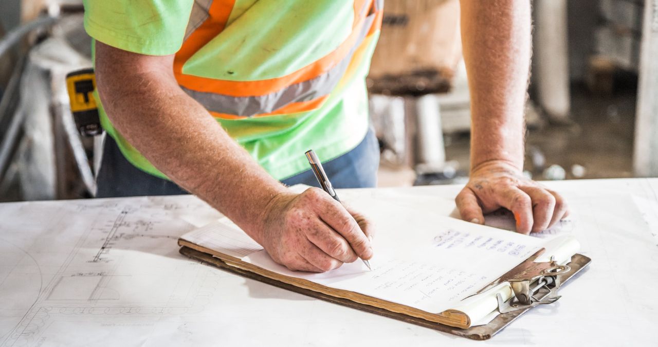 dodawanie buforu czasu do harmonogramu kobieta dodaje żółte karteczki z buforem czasu do listy zadań na biurkowym organizerze